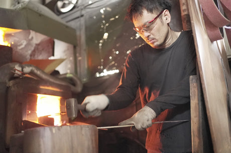 Satoshi Nakagawa hammers glowing steel at the forge in his Sakai workshop.