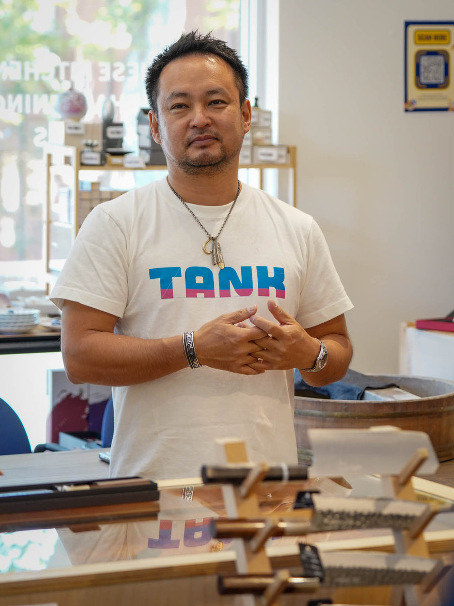 Takayuki Shibata behind the knife display counter at Knives & Stones, Sydney