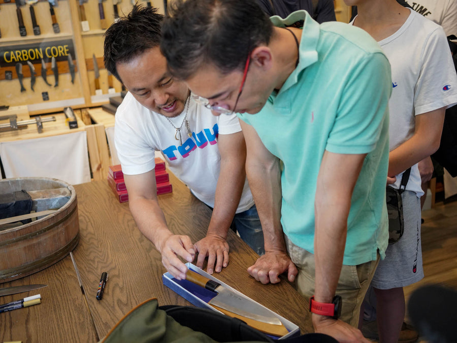 Shibata-san showing a knife to a customer at the Knives & Stones Sydney store