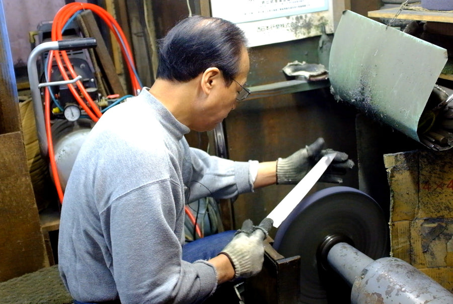 Hirotsugu Tosa sharpening a single-bevel blade at the belt sander