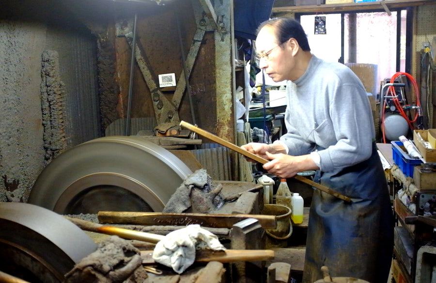 Hirotsugu Tosa at the water wheel with a blade in its wooden jig