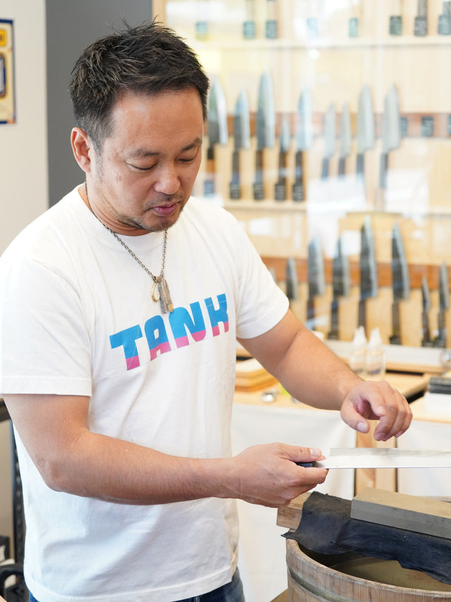 Shibata-san sharpening a blade on the whetstone at the Knives & Stones Sydney store